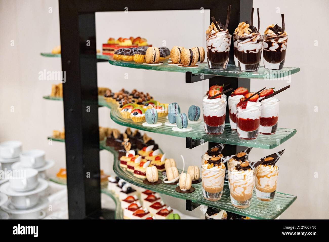 Verschiedene Arten von süßen Desserts, Mousse. Dessertbuffet mit Mousse aus weißer und dunkler Schokolade mit Früchten in einem Glas Stockfoto