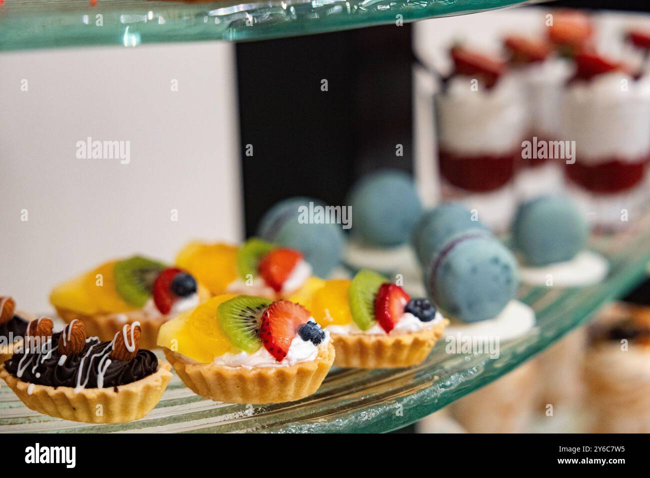 Köstliche Mini-Obsttarte auf einem Buffet-Tisch auf einem Konditorei mit verschiedenen fruchtigen Gebäckstücken mit selektivem Fokus auf einem Hochzeitsempfang Stockfoto