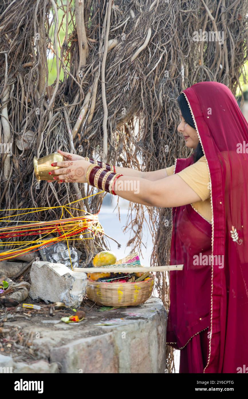 Gläubige verehren den heiligen Banyan-Baum mit Opfergaben am Tag anlässlich des Banyan-Baumverehrungsfestes, (MwSt. Savitri Puja) Indien. Stockfoto