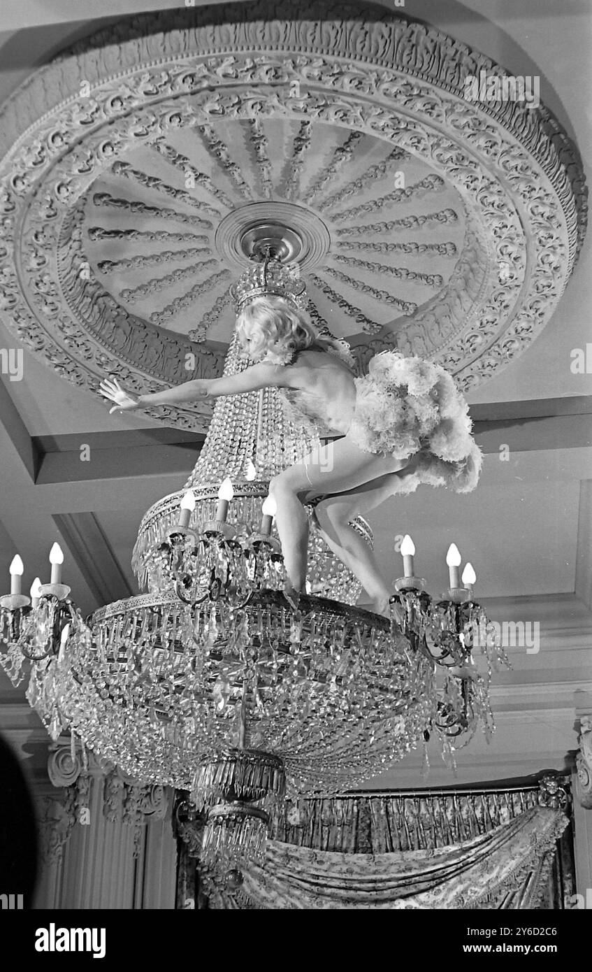 Die US-amerikanische Schauspielerin Caroll Baker zeigt in einer Szene aus ihrem Film die Carpetbaggers einen Striptease auf einem riesigen Kronleuchter . 8. September 1963 Stockfoto