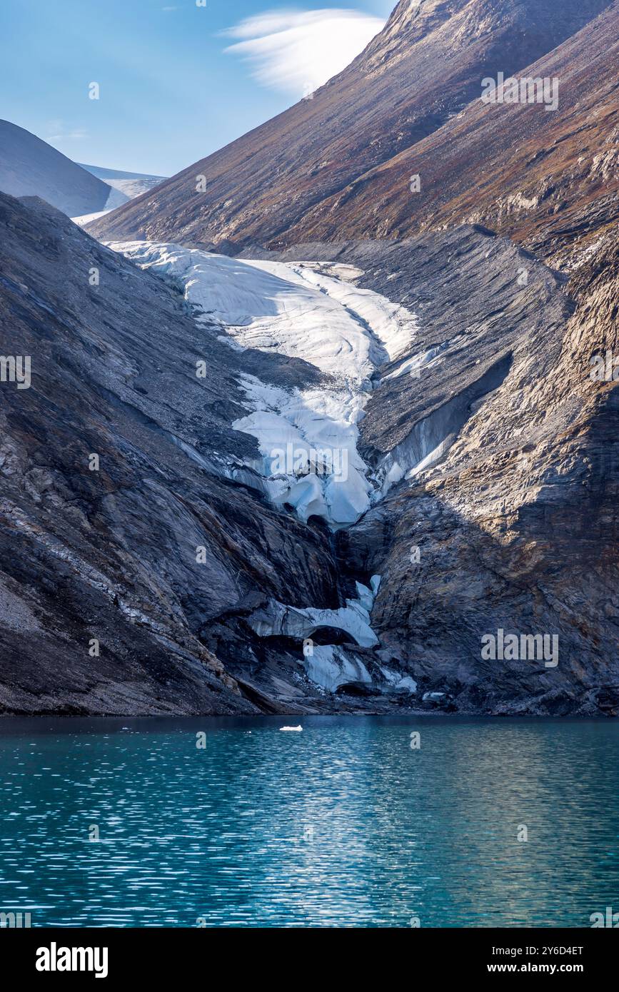 Hängender Gletscher im Dickson Fjord, Nordost-Grönland-Nationalpark, Arktis. Steil aufsteigende Berge und kalte blaue Fjordgewässer. Stockfoto