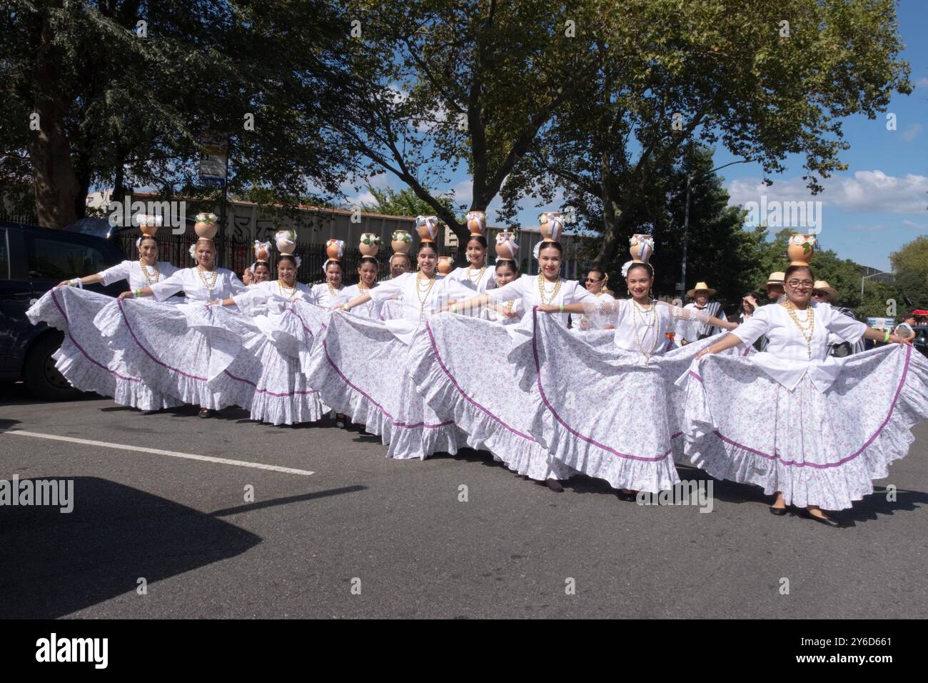 Eine Gruppe paraguayischer amerikanischer Volkstänzer, die ihre Röcke aushalten, posiert für ein Foto zu Beginn der Hispanic Heritage Parade in Jackson Heights. Stockfoto