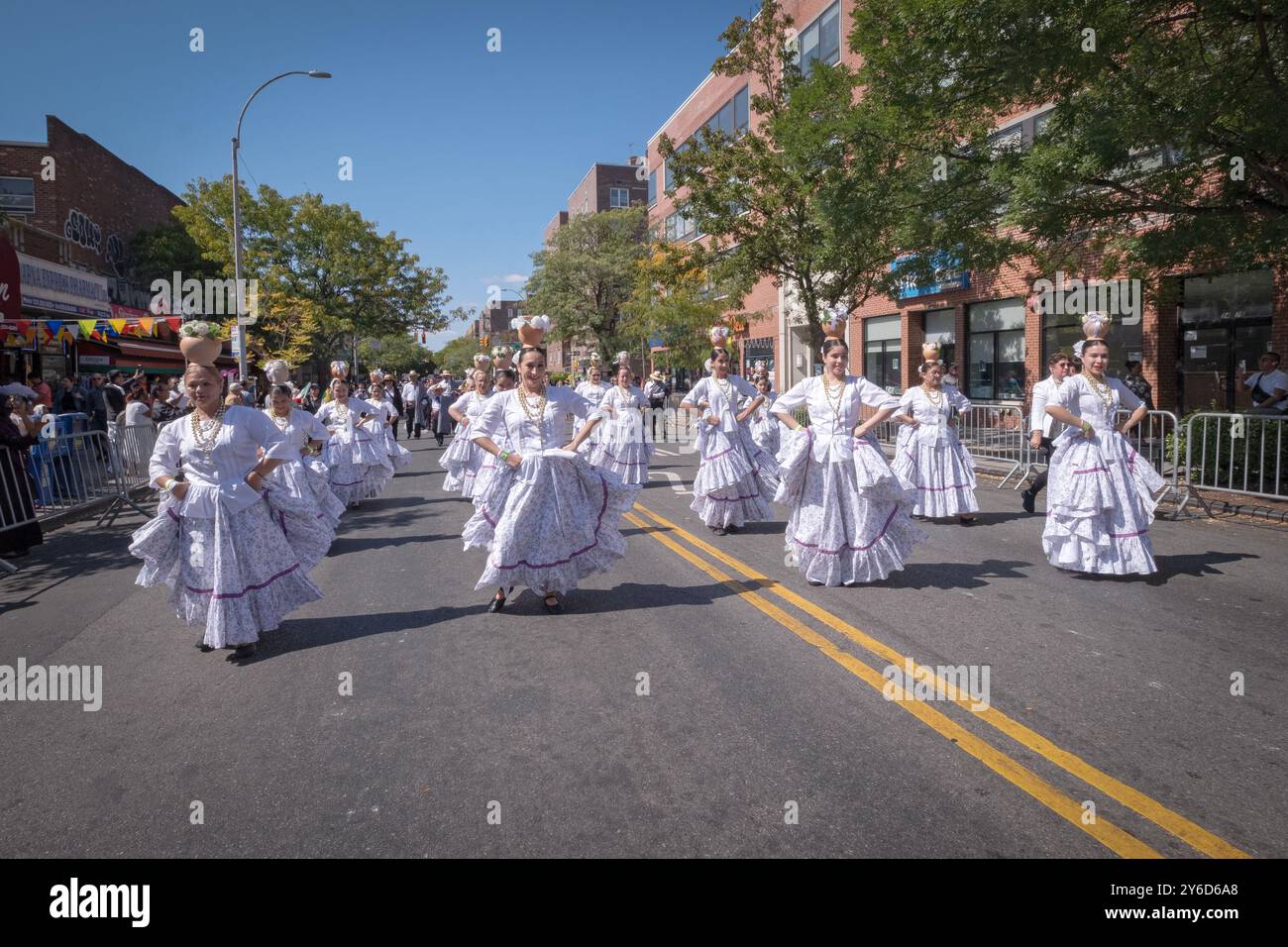 Eine Gruppe paraguayischer Frauen tanzen und marschieren in weißen Kostümen. Bei der Queens Hispanic Day Parade 2024 in Jackson Heights. Stockfoto