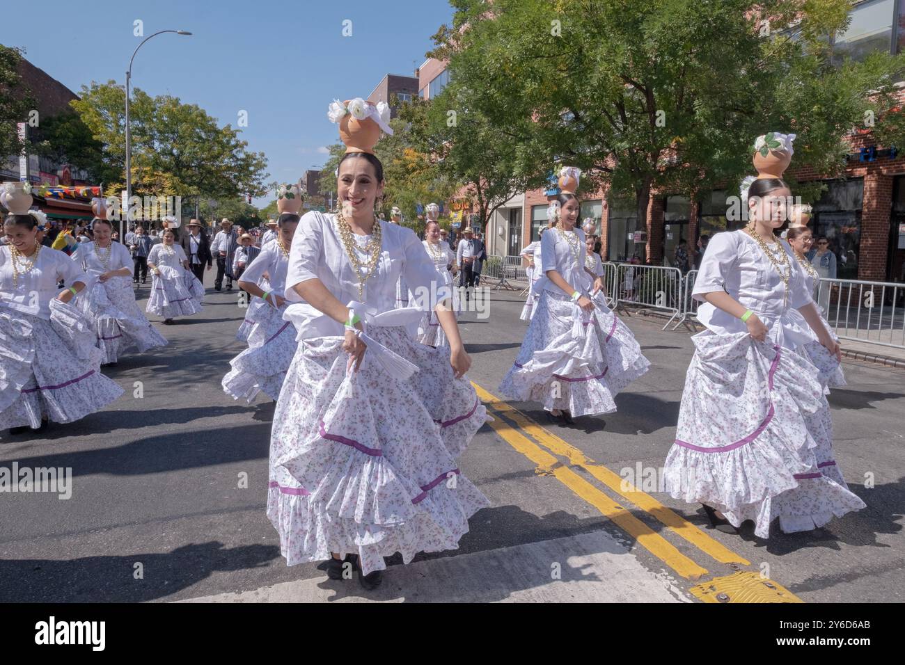 Eine Gruppe paraguayischer Frauen tanzen und marschieren in weißen Kostümen. Bei der Queens Hispanic Day Parade 2024 in Jackson Heights. Stockfoto