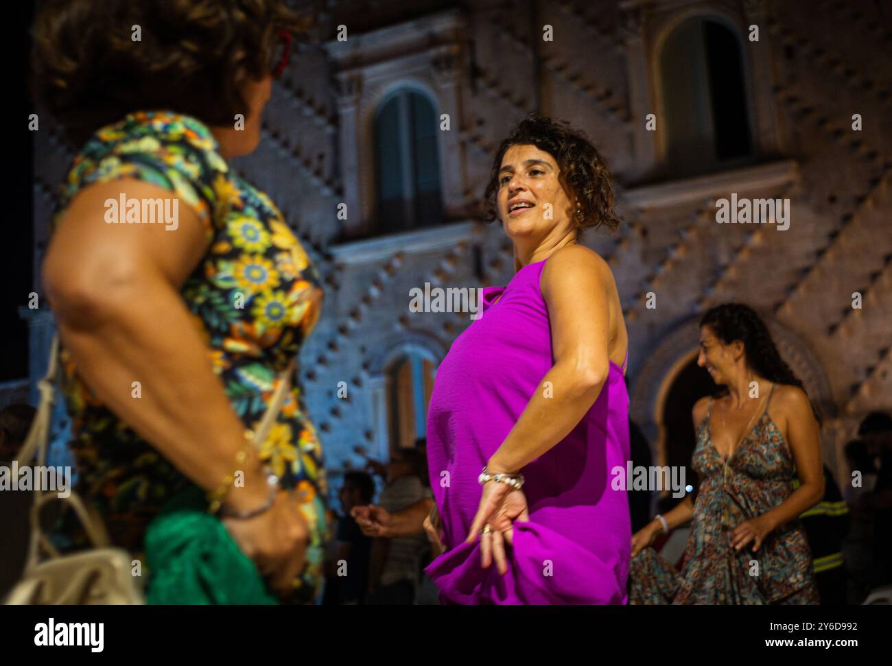 Die Leute genießen Pizzica-Tanz bei einem Konzert von Canzoniere Grecanico Salentino oder CGS in Alessano, Provinz Lecce, Apulien, Italien. Die Band spielt Tradit Stockfoto