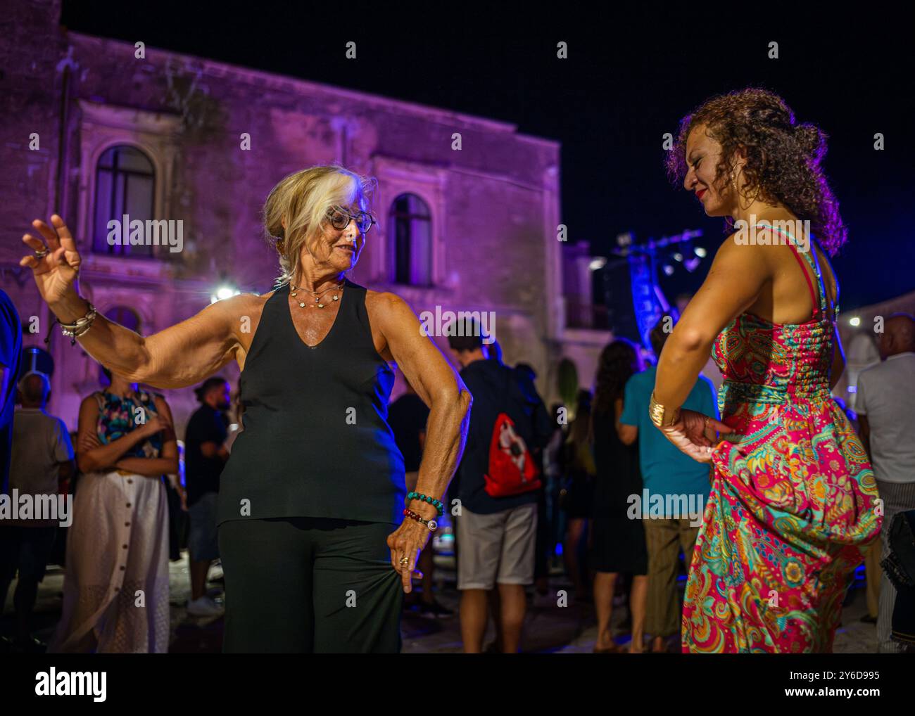 Die Leute genießen Pizzica-Tanz bei einem Konzert von Canzoniere Grecanico Salentino oder CGS in Alessano, Provinz Lecce, Apulien, Italien. Die Band spielt Tradit Stockfoto