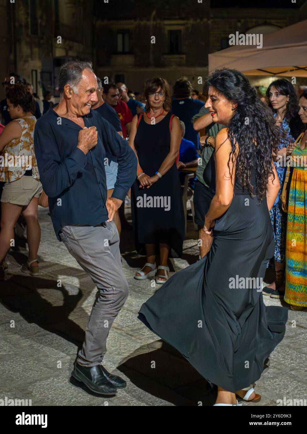 Die Leute genießen Pizzica-Tanz bei einem Konzert von Canzoniere Grecanico Salentino oder CGS in Alessano, Provinz Lecce, Apulien, Italien. Die Band spielt Tradit Stockfoto