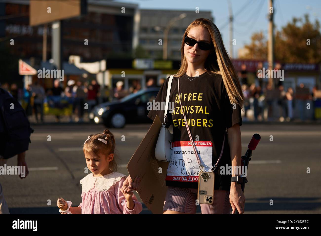 Fröhliche ukrainische Frau, die ein Hemd "Freie Asovstal-Verteidiger" bei einer öffentlichen Demonstration in Kiew trägt - 22. September 2024 Stockfoto