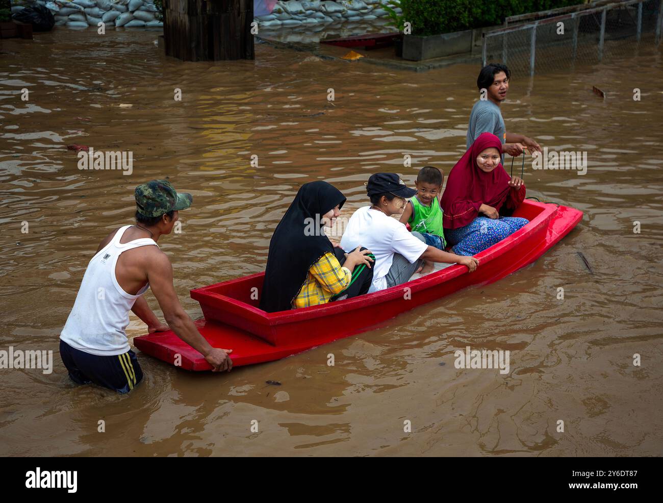 Chiang Mai, Thailand. September 2024. Die Bewohner fahren mit einem Paddelboot durch die überfluteten Straßen in der Gegend von Chang Khlan, nachdem der Ping-Fluss nach anhaltenden Regenfällen in Chiang Mai in Stadtgebiete übergelaufen ist. Die Überschwemmungen im Stadtgebiet von Chiang Mai, insbesondere im Bezirk Chang Khlan, sind auf mehrere Tage in Folge von starken Regenfällen zurückzuführen, die den Wasserstand im Ping River ansteigen und seine Ufer überlaufen. Das Hochwasser hat Häuser und mehrere Straßen überschwemmt. Die Behörden arbeiten nun daran, das Wasser abzuleiten und überwachen die Situation genau. Gutschrift: Stockfoto