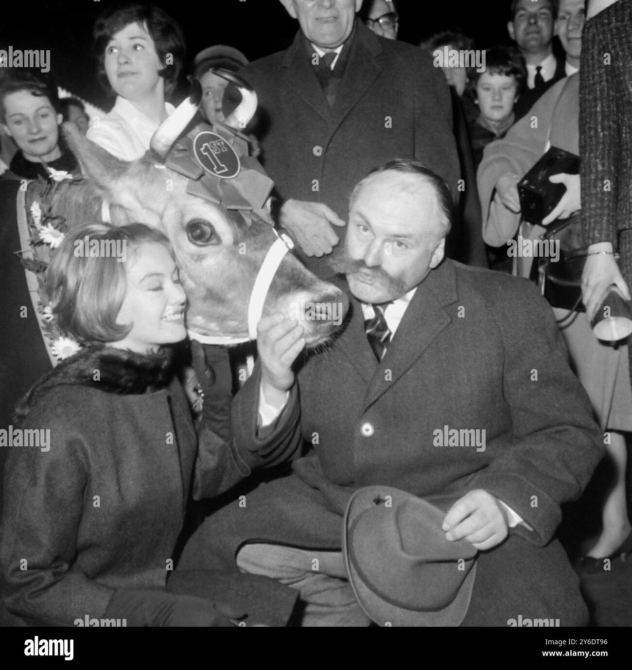 16. MÄRZ 1963 JANETTE SCOTT UND JIMMY EDWARDS MIT DEM PREIS FÜR DIE JERSEY-KUH WINNIE WILTS, DIE AUF EINER SONDERMISSION IST, UM PADDINGTON BOROUGH DABEI ZU HELFEN, 10,000 £ ZU SAMMELN, UM EINE ABFÜLLANLAGE IM RAHMEN DER KAMPAGNE „SAFE MILK FOR INDIA“ BEREITZUSTELLEN. PADDINGTON STATION, LONDON, ENGLAND. Stockfoto