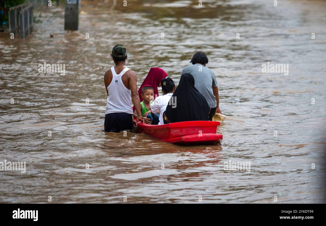 Chiang Mai, Thailand. September 2024. Die Bewohner fahren mit einem Paddelboot durch die überfluteten Straßen in der Gegend von Chang Khlan, nachdem der Ping-Fluss nach anhaltenden Regenfällen in Chiang Mai in Stadtgebiete übergelaufen ist. Die Überschwemmungen im Stadtgebiet von Chiang Mai, insbesondere im Bezirk Chang Khlan, sind auf mehrere Tage in Folge von starken Regenfällen zurückzuführen, die den Wasserstand im Ping River ansteigen und seine Ufer überlaufen. Das Hochwasser hat Häuser und mehrere Straßen überschwemmt. Die Behörden arbeiten nun daran, das Wasser abzuleiten und überwachen die Situation genau. Gutschrift: Stockfoto