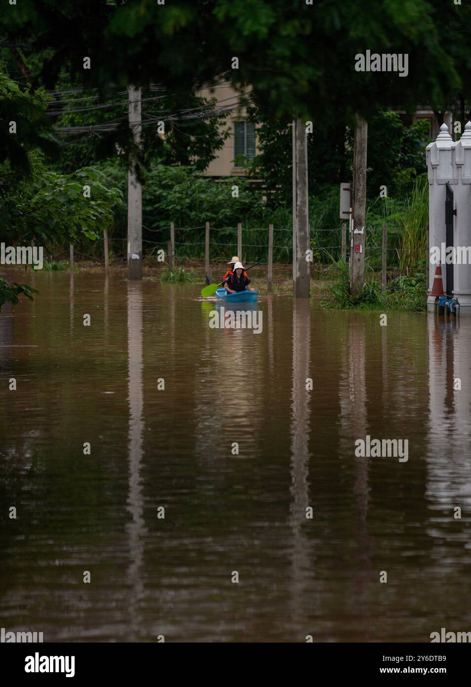 Chiang Mai, Thailand. September 2024. Die Bewohner fahren mit einem Paddelboot durch die überfluteten Straßen in der Gegend von Chang Khlan, nachdem der Ping-Fluss nach anhaltenden Regenfällen in Chiang Mai in Stadtgebiete übergelaufen ist. Die Überschwemmungen im Stadtgebiet von Chiang Mai, insbesondere im Bezirk Chang Khlan, sind auf mehrere Tage in Folge von starken Regenfällen zurückzuführen, die den Wasserstand im Ping River ansteigen und seine Ufer überlaufen. Das Hochwasser hat Häuser und mehrere Straßen überschwemmt. Die Behörden arbeiten nun daran, das Wasser abzuleiten und überwachen die Situation genau. Gutschrift: Stockfoto