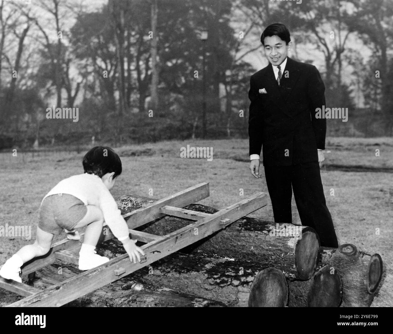 AM 24. DEZEMBER 1962 SIEHT KRONPRINZ AKIHITO VON JAPAN, DER GERADE 29 JAHRE ALT IST, WIE SEIN SOHN PRINZ HIRO IN DEN GÄRTEN DES KRONPALASTES IN TOKIO SPIELT. Stockfoto