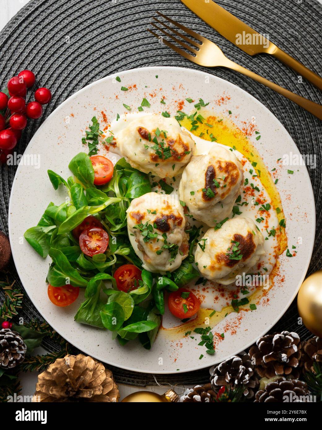 Gefüllte Eier auf Gratin mit Béchamelsauce. Tisch mit Panoramablick und Weihnachtsdekoration. Stockfoto