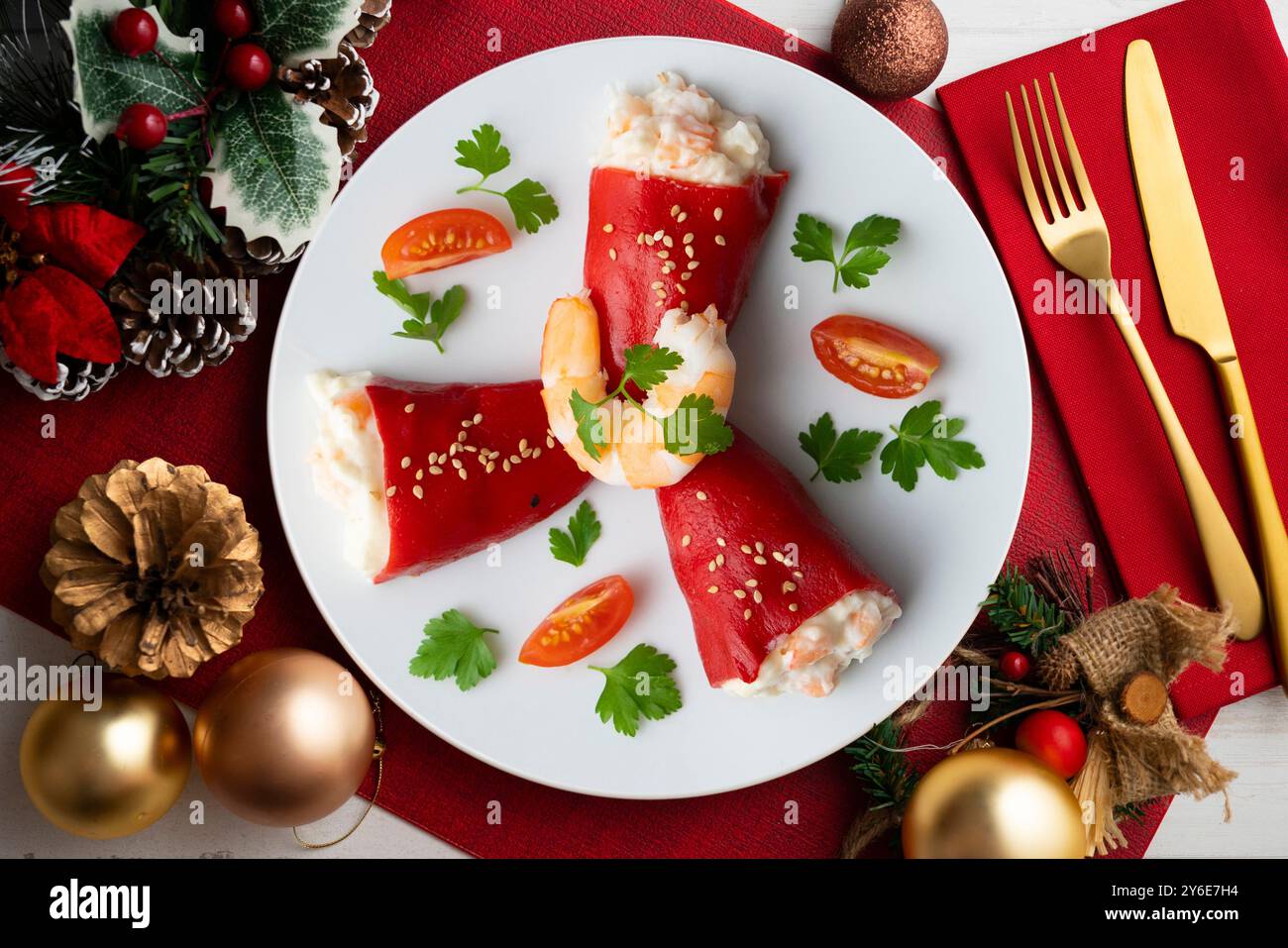 Rote Piquillo-Paprika gefüllt mit Kabeljau. Tisch mit Panoramablick und Weihnachtsdekoration. Stockfoto