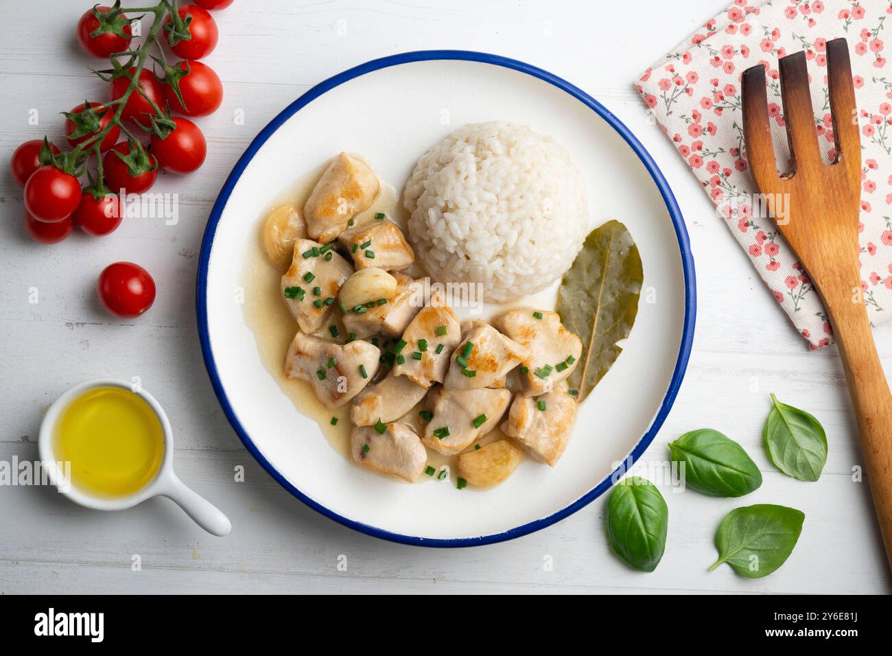 Knoblauchhähnchen mit Lorbeerblatt-Aroma und weißem Reis. Tisch mit Draufsicht und Dekoration. Stockfoto