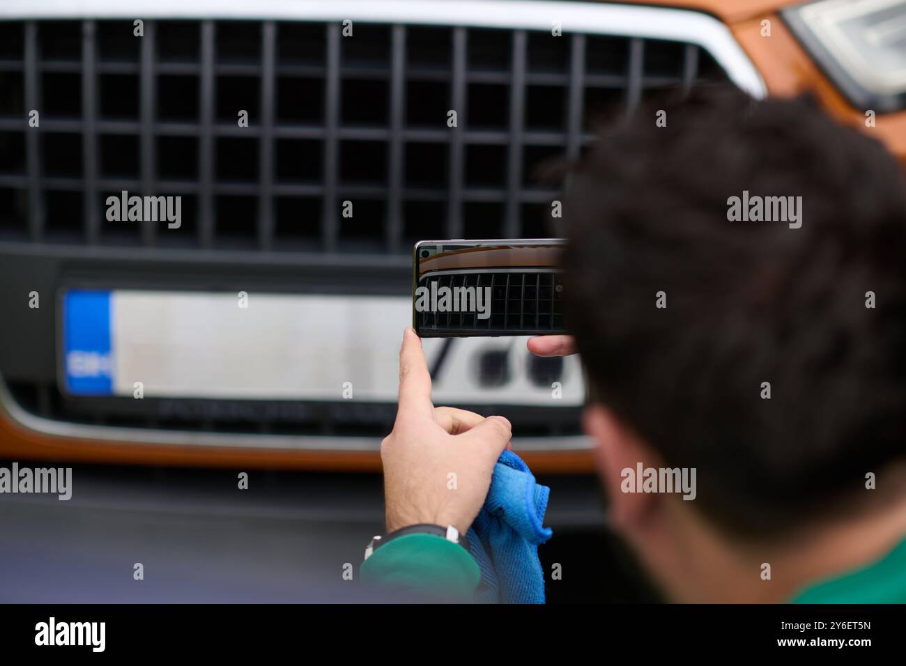 Den Moment festhalten: Ein Mann fotografiert sein Auto zum Verkauf, um es online zu teilen Stockfoto