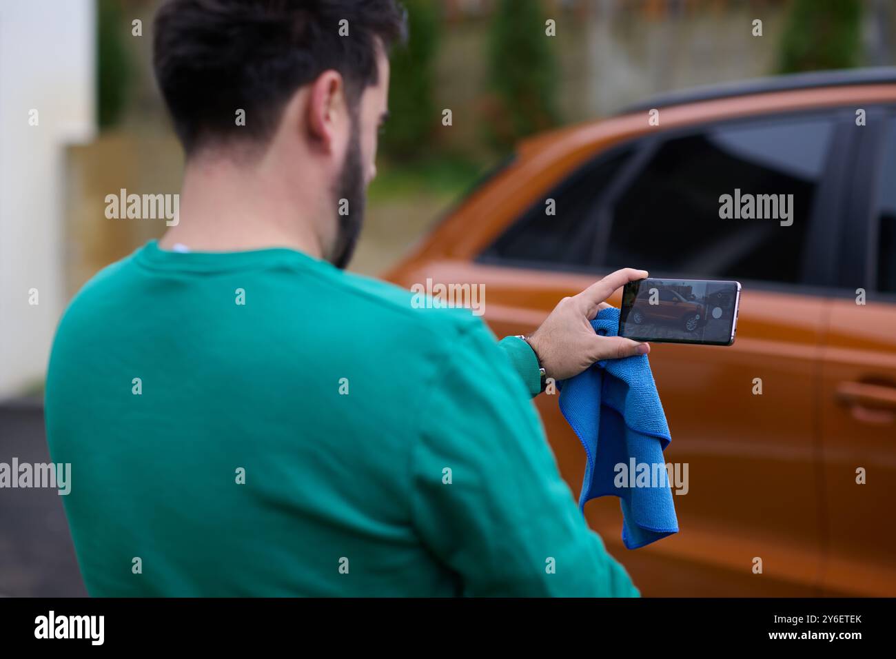 Den Moment festhalten: Ein Mann fotografiert sein Auto zum Verkauf, um es online zu teilen Stockfoto