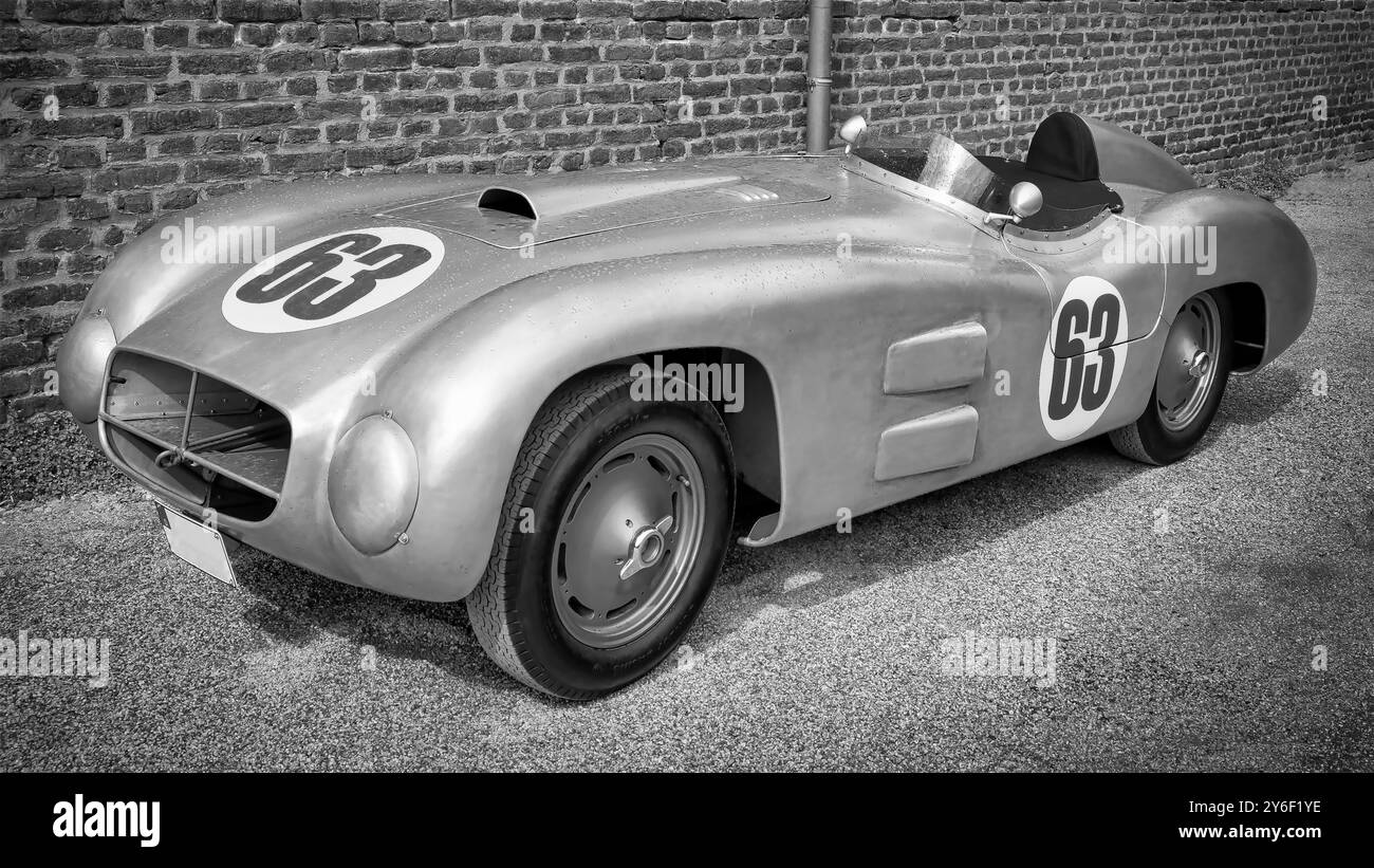 Ein alter, silberner Vintage-Rennwagen mit Aluminiumkarosserie auf einem minimalistischen Schwarz-weiß-Foto. Stockfoto