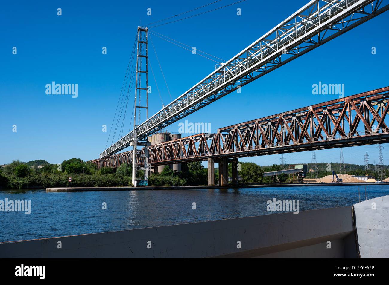 Visé, Wallonien, Belgien, 11. August 2024 - Industrieleitung und Eisenbahnbrücke über den Albert-Kanal Stockfoto