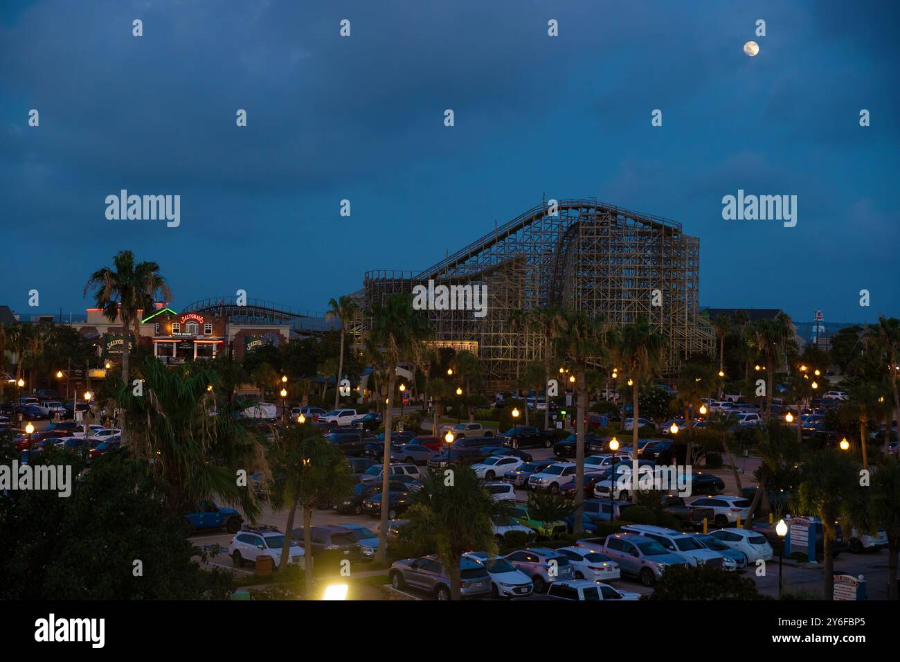 Kemah, Texas, USA – 21. Juni 2024: Die hölzerne Achterbahn Bullett steht hoch unter dem bewölkten Himmel und einem Vollmond. Stockfoto