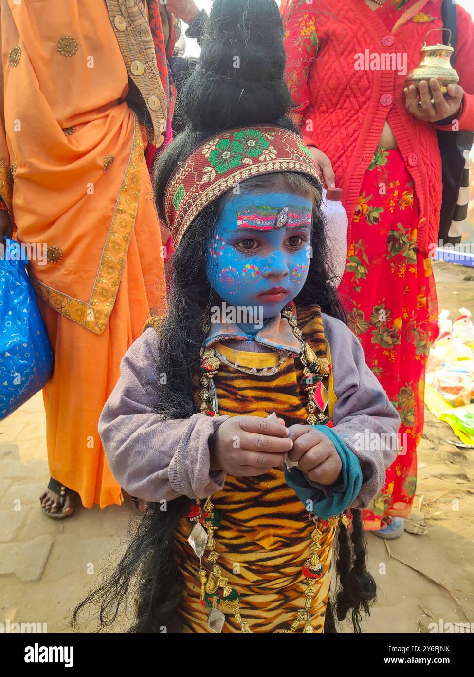 PRAYAGRAJ, UTTAR PRADESH, INDIEN - 14. AUGUST 2023: Ein indisches Künstlermädchen, das als hinduistischer Gott gekleidet ist, nimmt an einer religiösen Prozession Teil Stockfoto