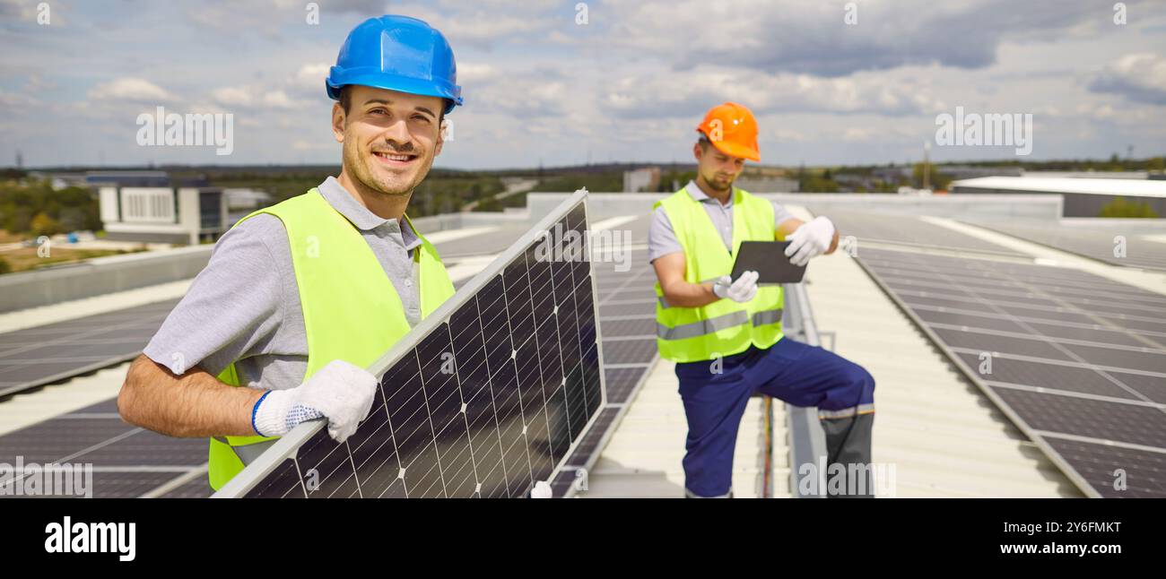 Team von Elektroingenieuren, die Photovoltaik-Solarpaneele installieren und die Kamera betrachten. Stockfoto