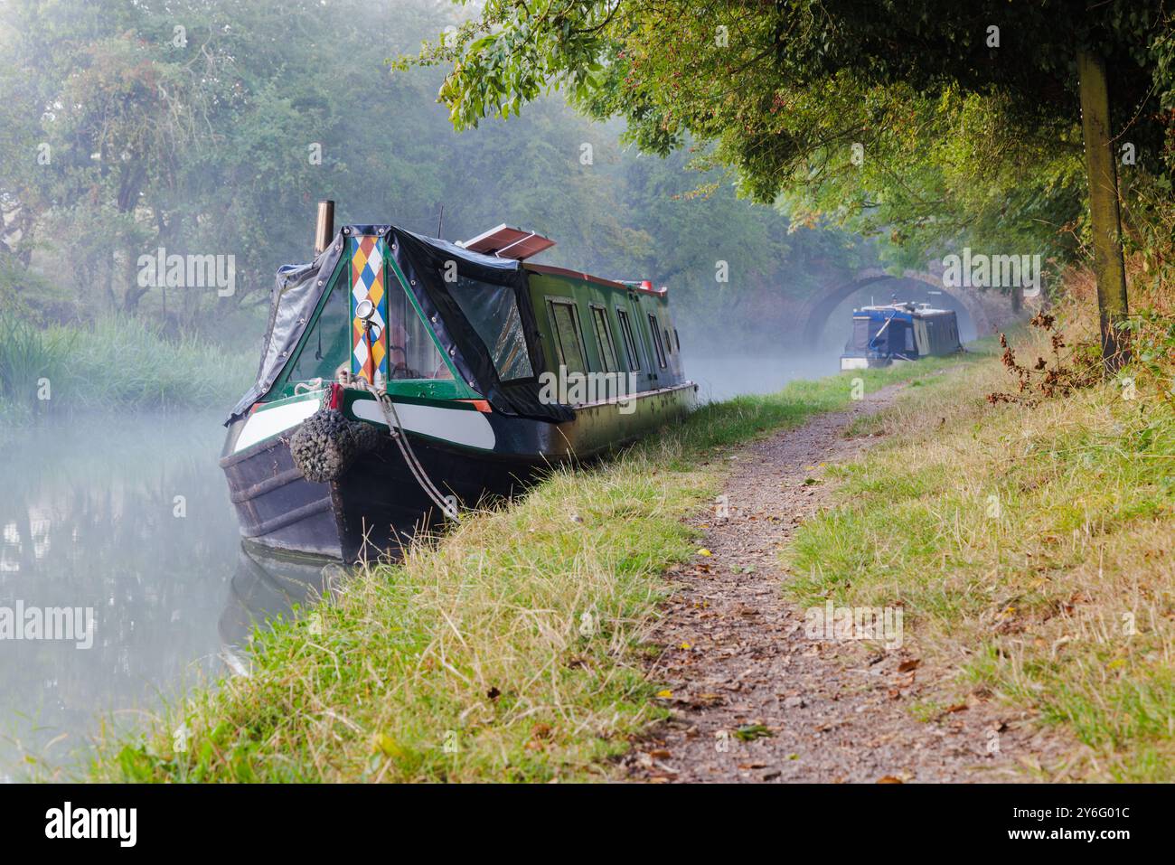 An einem nebeligen Morgen liegen zwei Schmalboote auf dem Schleppweg am Grand Union Canal nahe Crick, Northamptonshire. Stockfoto