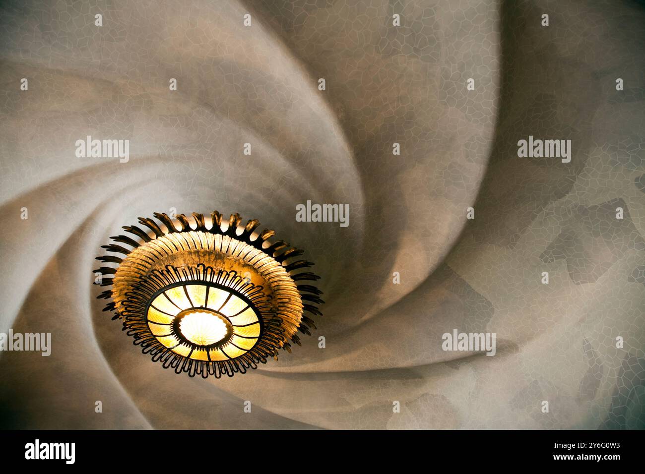 Barcelona, Spanien, 4. September 2008, bestaunen Sie das wirbelnde Deckenmuster, das mit einem kunstvollen Kronleuchter verziert ist und die architektonische Brillanz von Gaudí zeigt Stockfoto