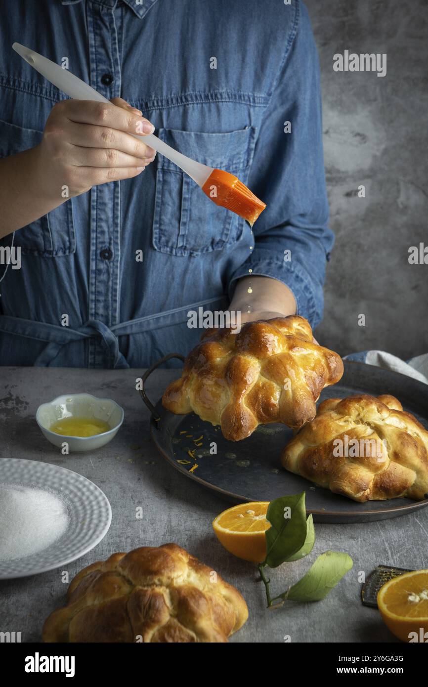 Lebensmittelfotografie, Frau, die Pan de muertos Tote für den mexikanischen Tag der Toten zubereitete Stockfoto