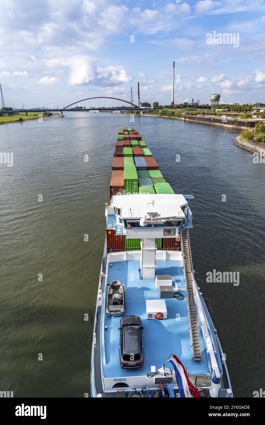 Das mit Containern beladene holländische Frachtschiff Vrido auf dem Rhein bei Duisburg, das hinter der sogenannten Solidaritätsbrücke über den Rhein hinabfährt; Stockfoto