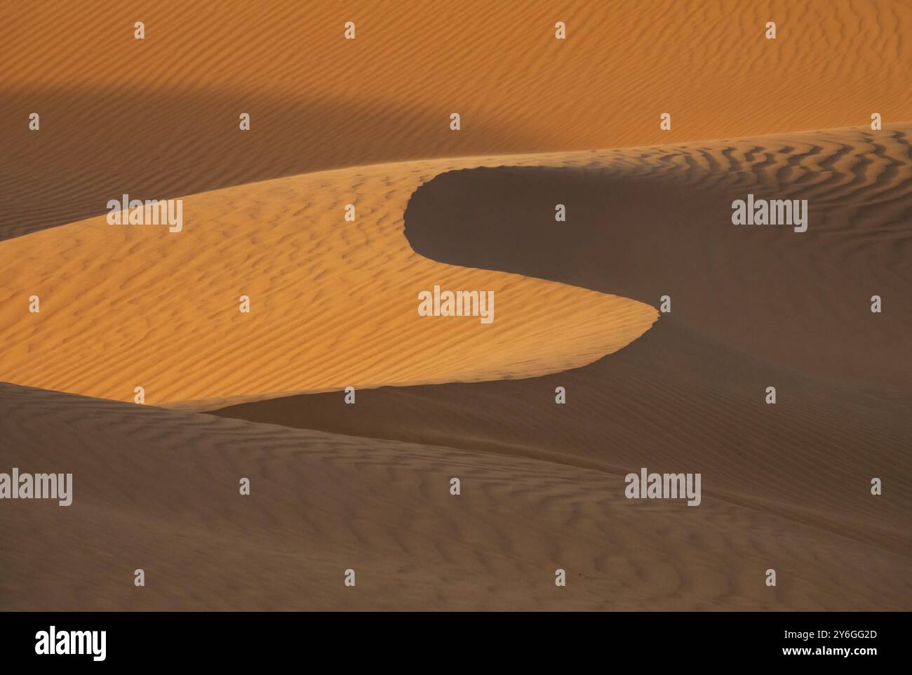 Hintergrund mit schönen Strukturen von sandigen Dünen bei Sonnenaufgang in der Wüste Sahara Stockfoto