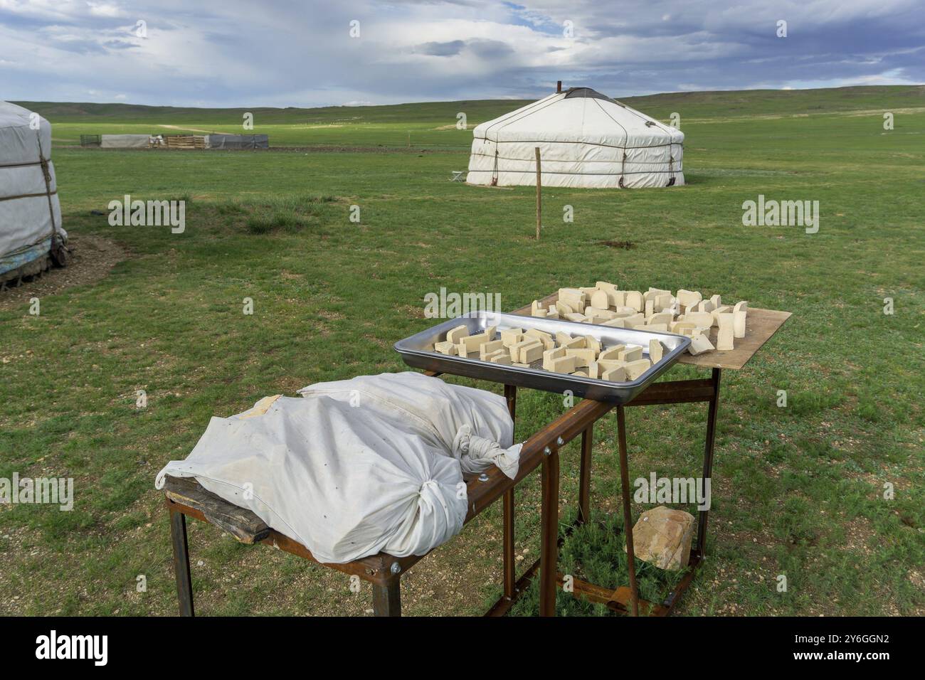 Mongolisches Milchprodukt Aaruul oder Gurt, hergestellt aus getrockneter Sauermilch, die mit typischem Ger im Hintergrund getrocknet wird Stockfoto