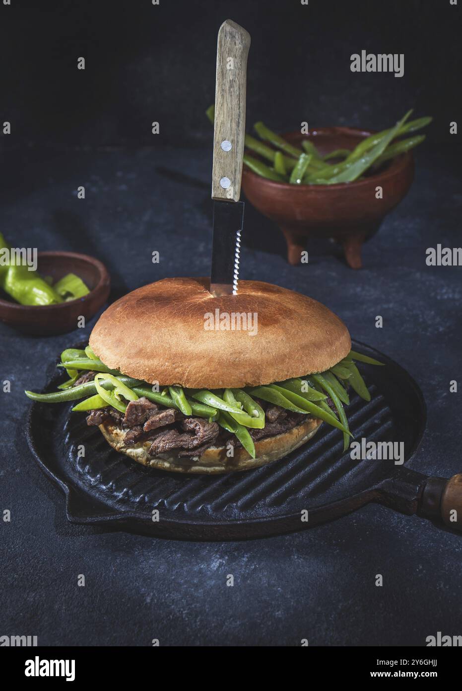 Essen, Essen, chilenischer lateinamerikanischer Sandwich-Burger Chacarero mit erstklassigen Rindfleischscheiben und grüner Bohne auf schwarzem Hintergrund Stockfoto