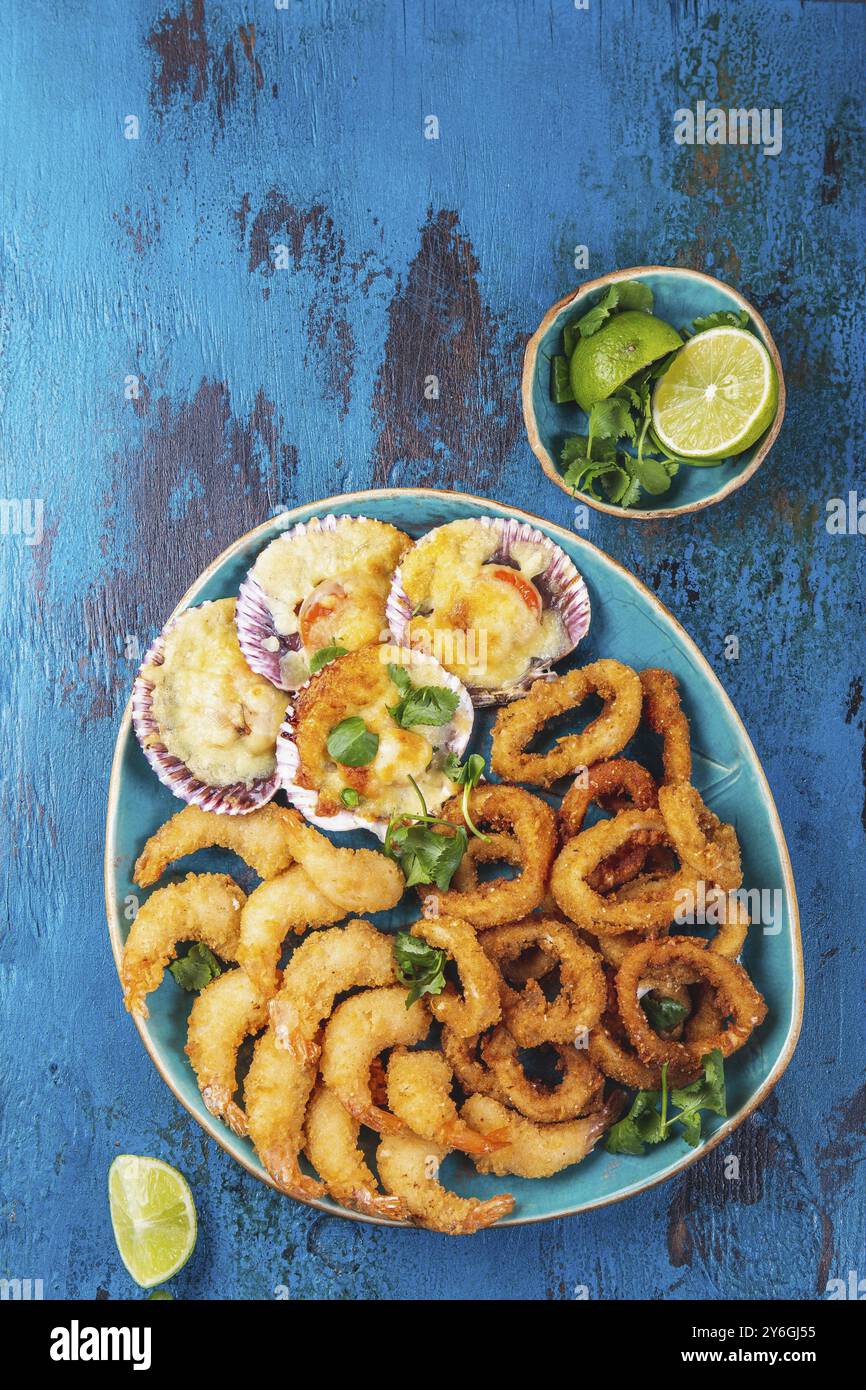 Essen, MEERESFRÜCHTE, heiße Platte gebackene Jakobsmuscheln, gebratene Tintenfischringe und Shimps Stockfoto