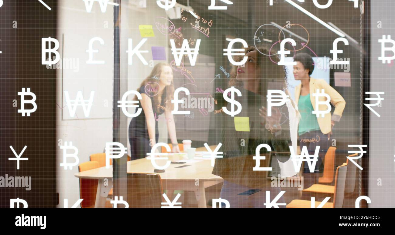 Bild von Währungssymbolen über verschiedenen Geschäftsleuten, die über die Arbeit im Büro sprechen Stockfoto