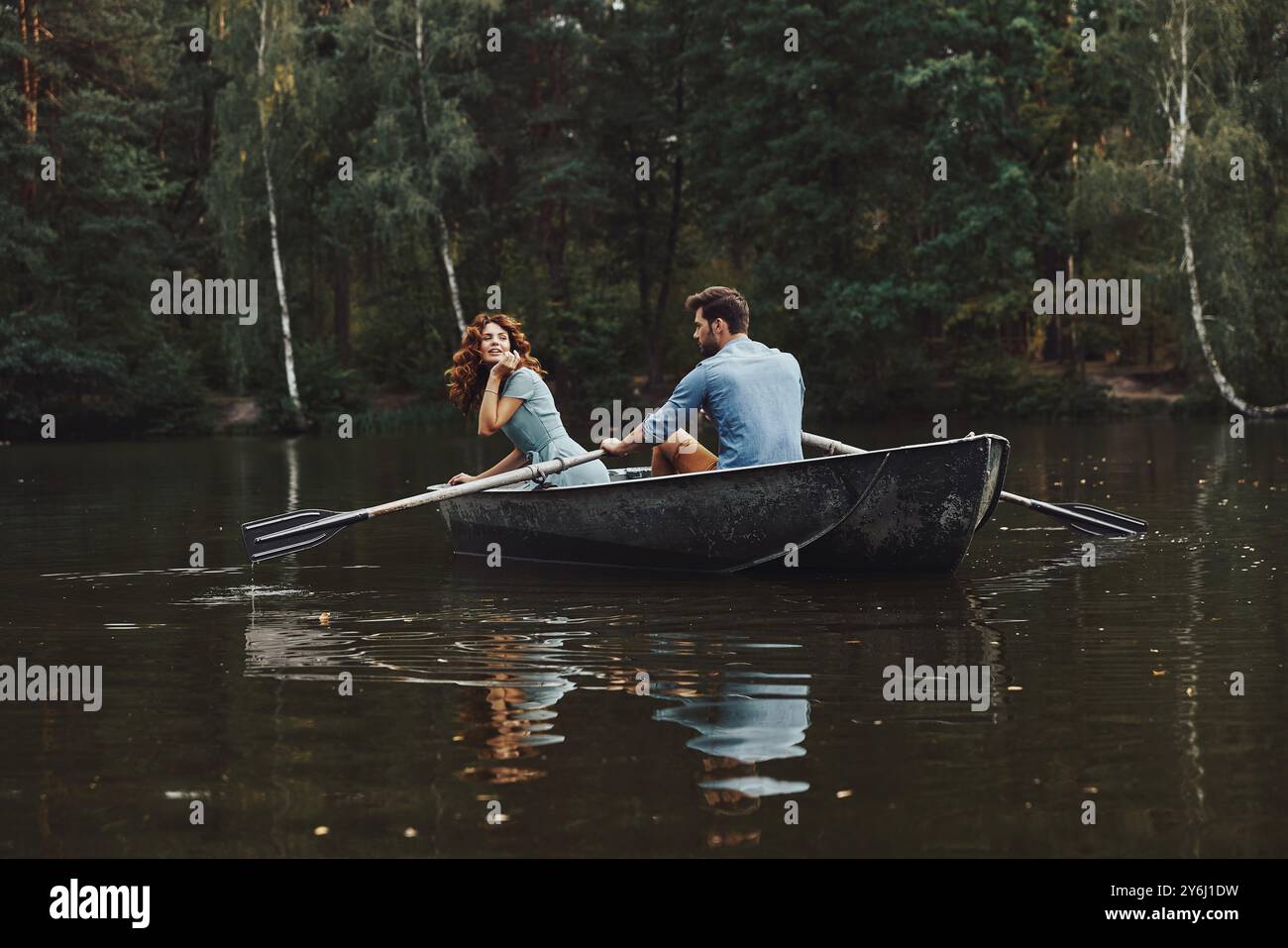 Keine Sorge. Wunderschönes junges Paar genießt romantisches Date und lächelt beim Rudern auf dem Boot Stockfoto