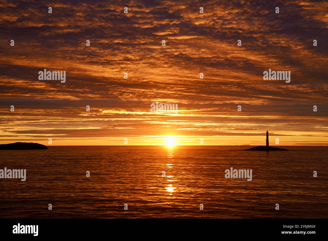 Sonnenuntergang über dem Ozean in der Nähe von Vevang, Norwegen mit tiefrotem Horizont, Teil der Atlantischen Ozean-Straße. Stockfoto