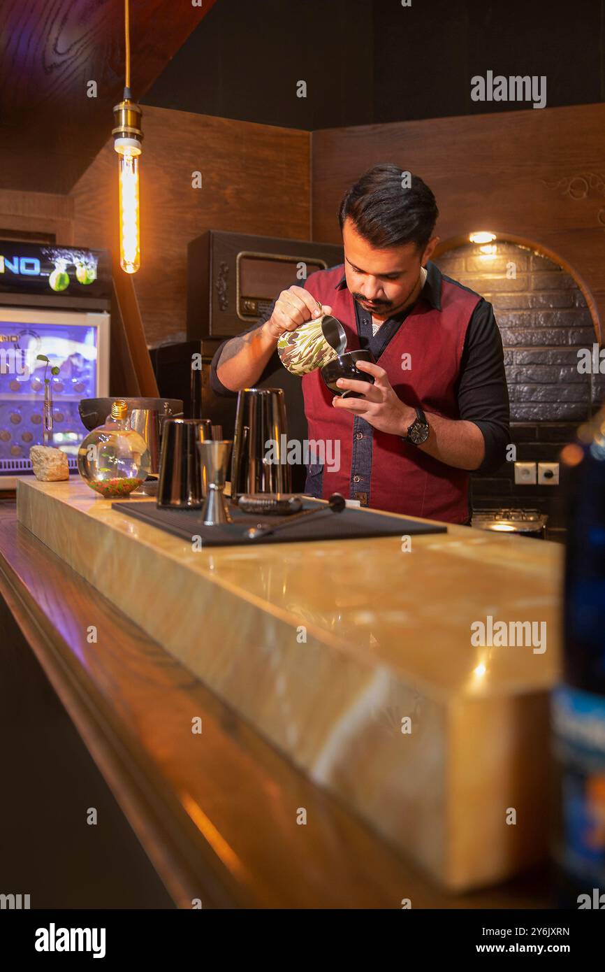 Barista bereitet Kaffee in einem persischen Café mit einladendem Ambiente und traditioneller Einrichtung zu Stockfoto