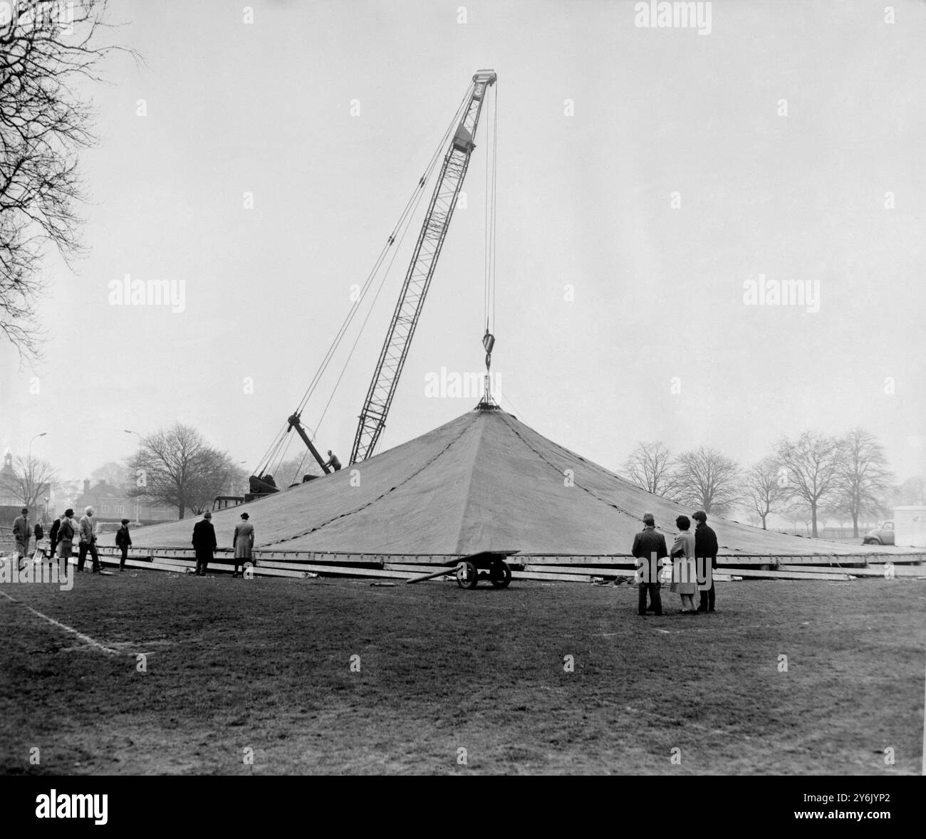 Allgemeiner Überblick über den 35 Tonnen schweren Kran, der das 25 Tonnen schwere Big Top auf dem Richmond Athletic Grounds in Vorbereitung auf seine Weltpremiere in cinerama am 17. April errichtete . Das Super Cinerama Mobile Theater ist das erste Tourenkino in diesem Land seit dem Ersten Weltkrieg . Der Film , der im 128 Fuß Durchmesser , 1216 Sitzer Theater gezeigt wird , ist " This is Cinerama " . Das Theater verfügt über die größte Kinoleinwand Großbritanniens - 103 Meter breit und 37 Meter tief . Nach dem zweiwöchigen Aufenthalt wird es Südengland besuchen. Das große Top wurde von Stromeyer in der Bundesrepublik Deutschland hergestellt. April Stockfoto