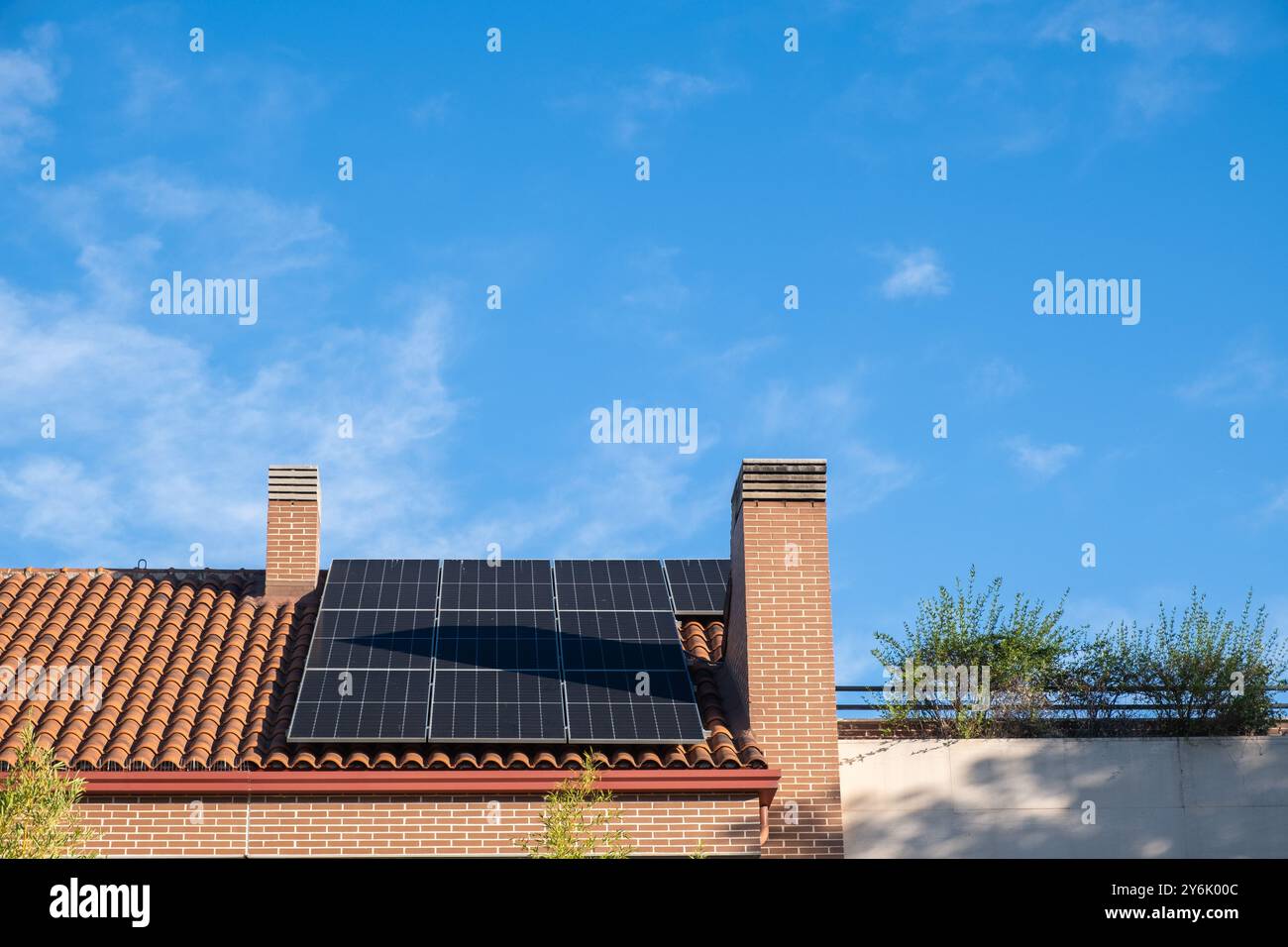 Detail des gekachelten Daches eines Einfamilienhauses mit Solarpaneelen. Konzept der Pflege des Planeten, nachhaltiges Wachstum und saubere und unerschöpfliche Sonne Stockfoto