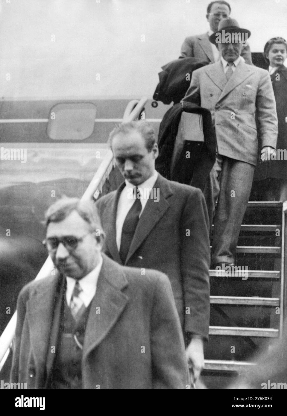 Lord Montagu von Beaulieu (zweiter aus der Kamera) , für dessen Verhaftung in England ein Haftbefehl ausgestellt wurde, der das Flugzeug bei seiner Ankunft in Paris aus New York verlässt. Einem New Yorker Bericht zufolge ist er nach Frankreich geflogen, um sich mit seinen Anwälten zu treffen. Lord Montagu, gerade mal 27, verließ Großbritannien vor fast zehn Wochen. Er verbrachte über drei Wochen in Amerika, wo er sich einer medizinischen Behandlung unterziehen soll. Oktober 1953 Stockfoto