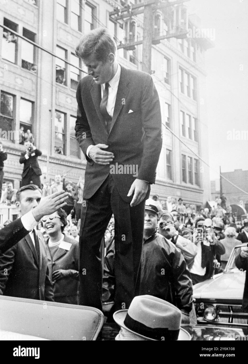 Aliquippa USA . Seine persönliche Unterstützung, um mehr Demokraten für den Kongress zu gewinnen Präsident John Kennedy steht auf einem Auto in der Innenstadt von Aliquippa auf der Straße . An diesem Punkt sieht der Chief Executive einen Mann, der seine Hand zum Gruß ausstreckte. Das Foto wurde am 24. Oktober 1962 gedreht. Stockfoto