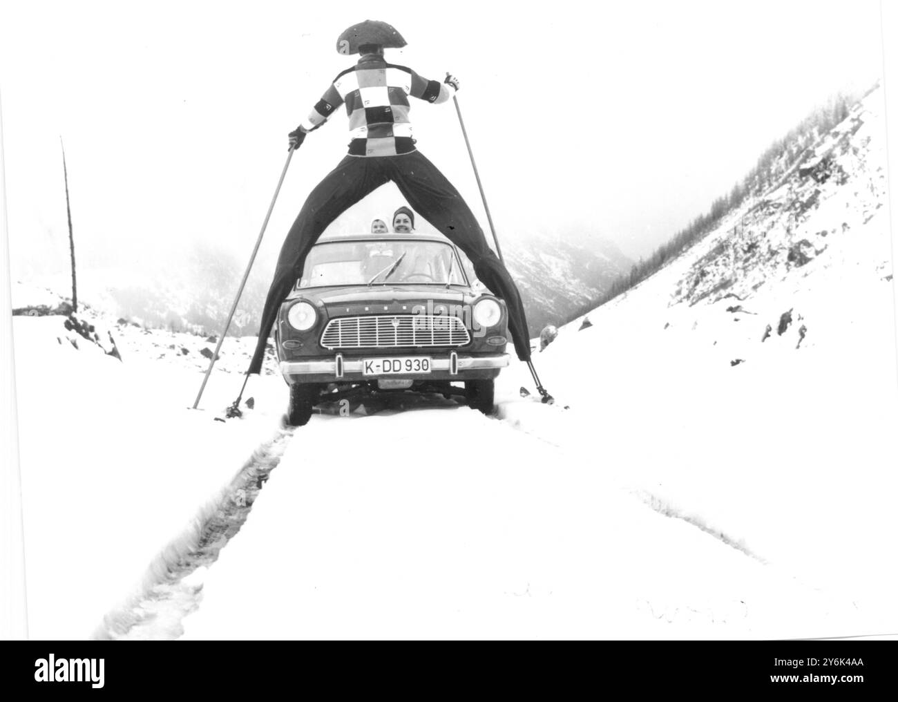 Stelzenmann Jeannot Turnier überquert das Taunusgebirge auf seinen eingeschraubten Eisenbeinen , an denen die Autofahrer unter ihm vorbeifahren müssen, um an ihm vorbei zu kommen , Mainz, Deutschland 12. März 1965 Stockfoto