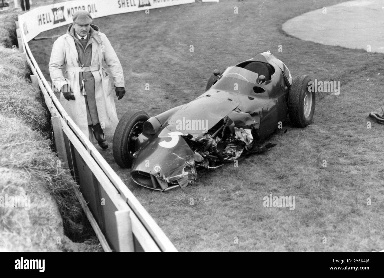 Goodwood England French Racing Fahrer Jean Behra und sein BRM nach einem Sturz in die Wand während der dritten Runde des Goodwood International 100 Meilen Rennens . 7. April 1958 Stockfoto