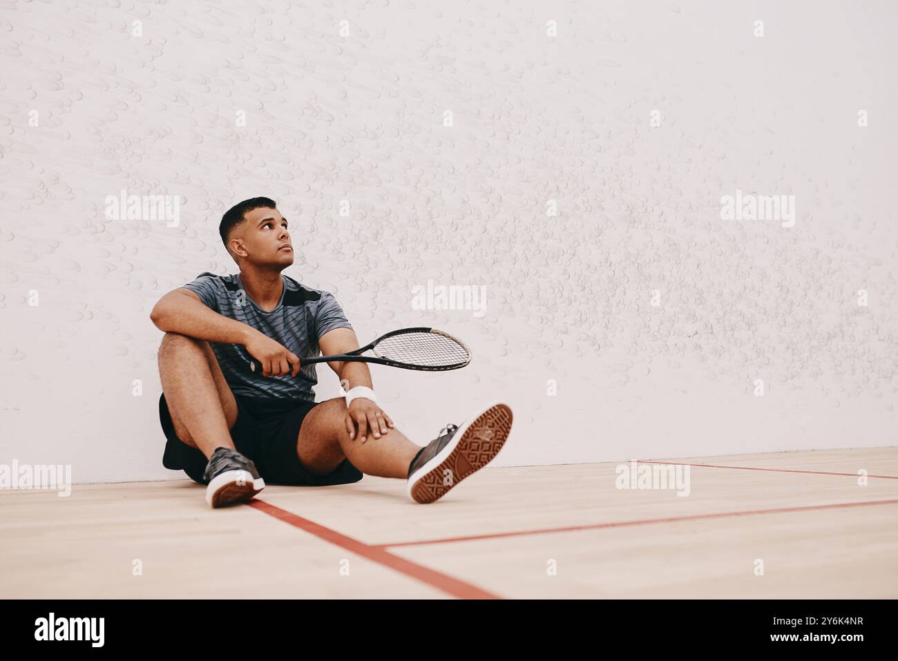 Mann, Tennisplatz und Denken auf dem Boden mit Schläger auf Training für Sport, Spiel und Turnier. Männlicher Mensch, Spieler und Vision auf Pause beim Training Stockfoto