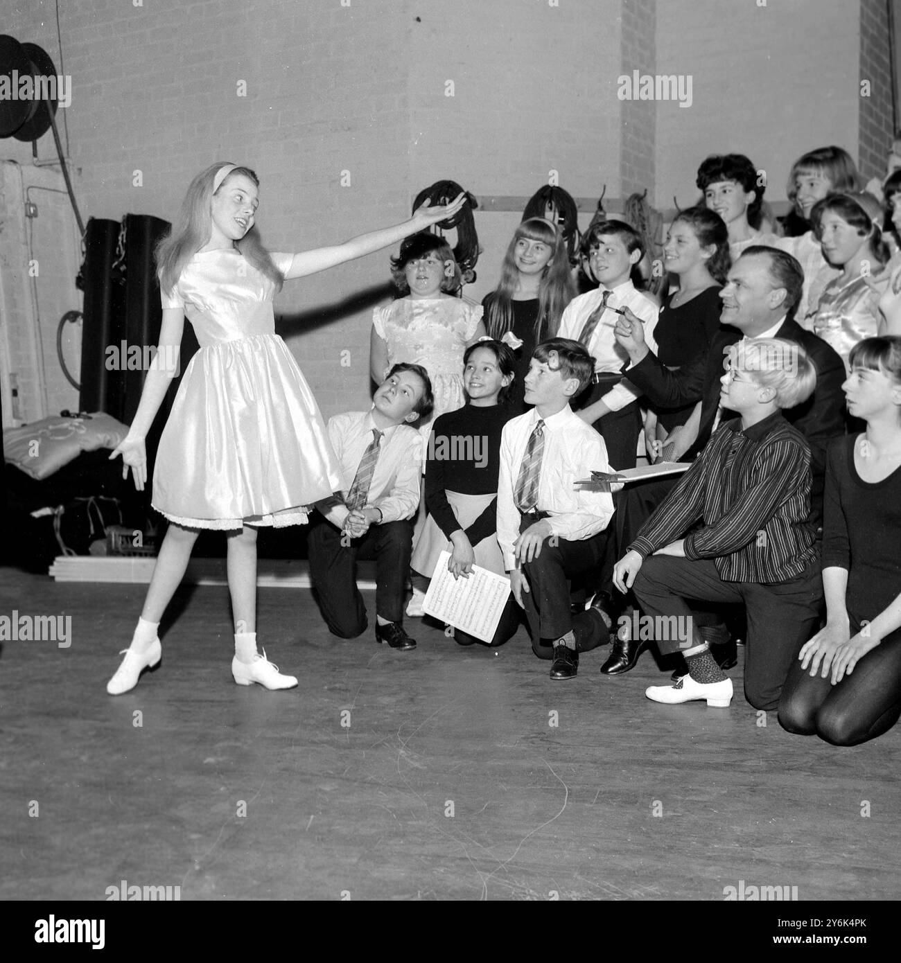 Die fünfzehnjährige Sheila White ( links ) unterhält heute im Prince Charles Theatre Impressario Harold Fielding und andere Jugendliche Aspiranten mit ihrem Song und Tanz während eines Vorspiels für die kommende Harry Corbett & " Sooty " Show , die die Weihnachtsattraktion im Prince Charles Theatre sein wird . Dezember 1963 Stockfoto