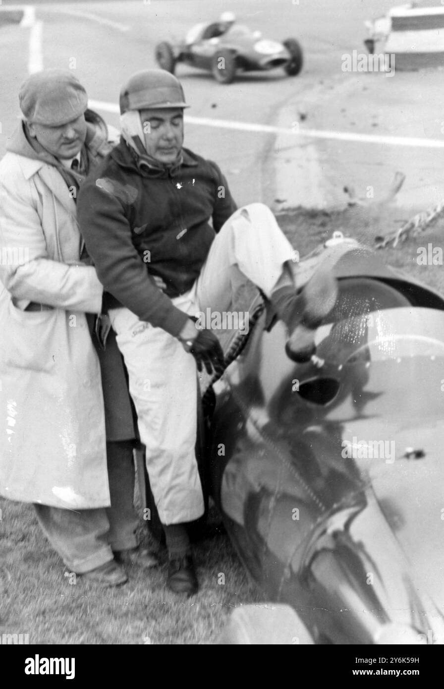 Jean Behra, Fahrer von Goodwood England French Racing, wird nach einem Unfall in der dritten Runde des Goodwood International 100 Meilen Rennens aus seinem BRM unterstützt . 7. April 1958 Stockfoto