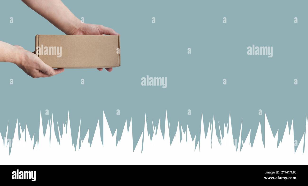 Pappschachtel in den Händen. Blauer monochromer Hintergrund. Weiße Eiszapfen, Illustration. Winterkonzept. Pakettransport, Einkaufen, Konsum Stockfoto