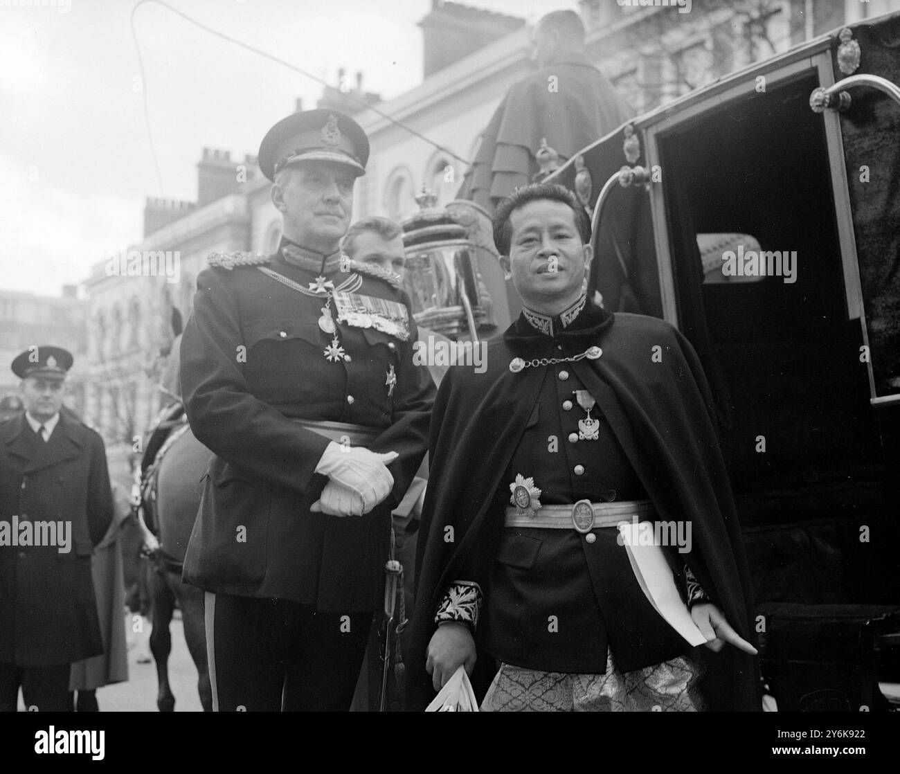 Der kambodschanische Botschafter von San Sary in London wird zusammen mit dem Queens Messenger Sir Guy Salisbury Jones gesehen, als er 24 Phillimore Garden Kensington am 12. Februar 1958 nach Buckingham Palace verließ Stockfoto